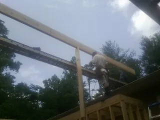 Carpenter setting a ridge beam over a new addition frame — Ice Dam Removal by Roofing Brothers in Belmont