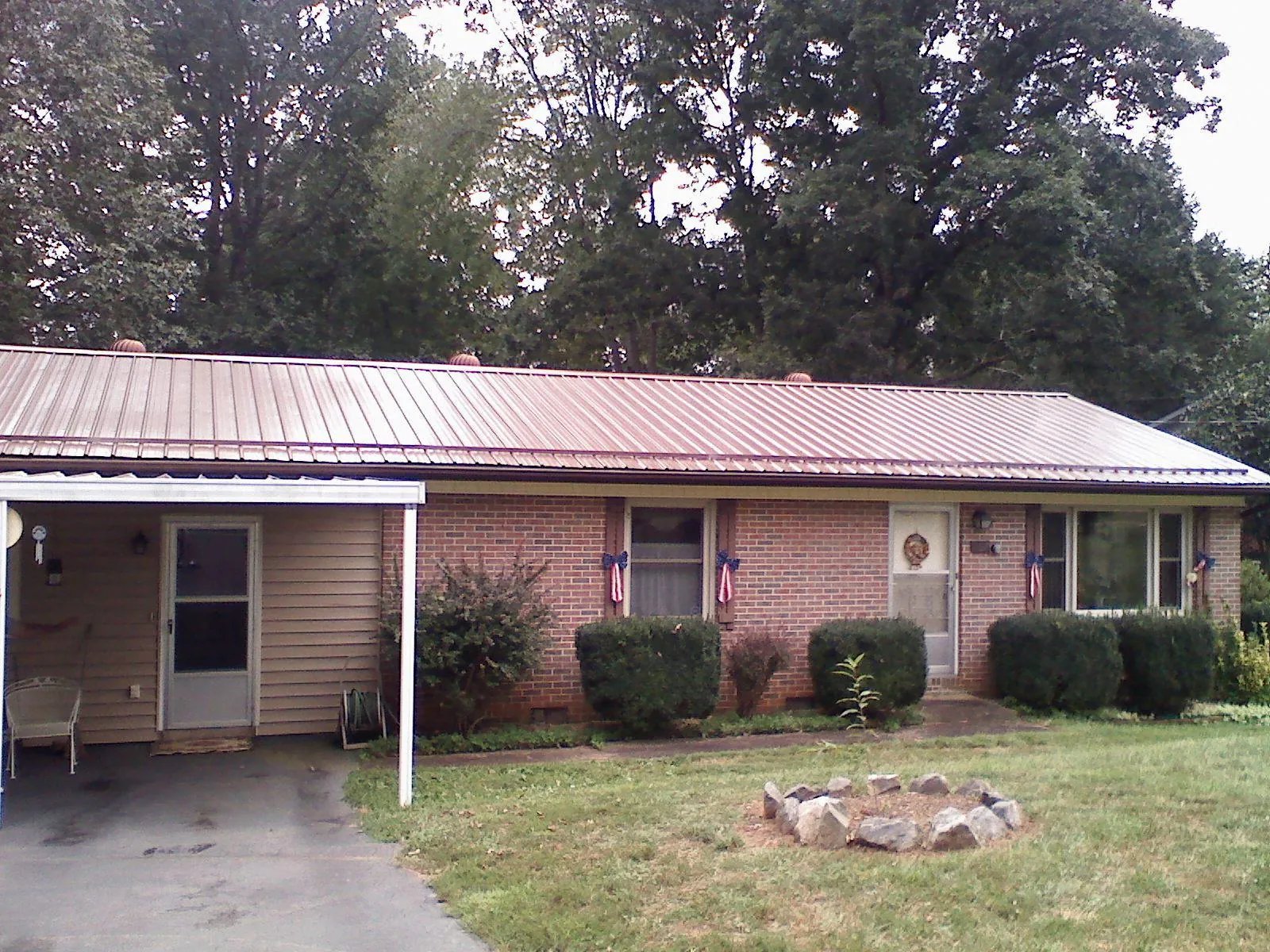 Bronze metal roof and carport on a brick ranch home — Roof Repair work by our crew in Belmont